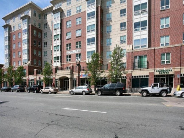 a city street with cars parked in front of tall buildings