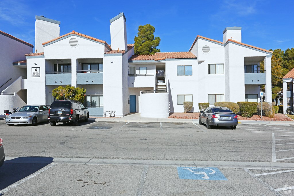 an empty parking lot in front of an apartment building