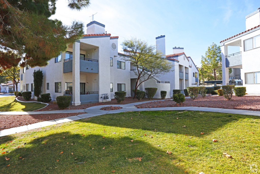 an exterior view of a building with green grass and trees