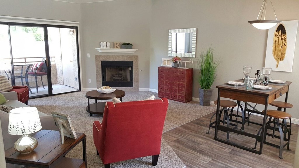 a living room with a fireplace and a table and chairs