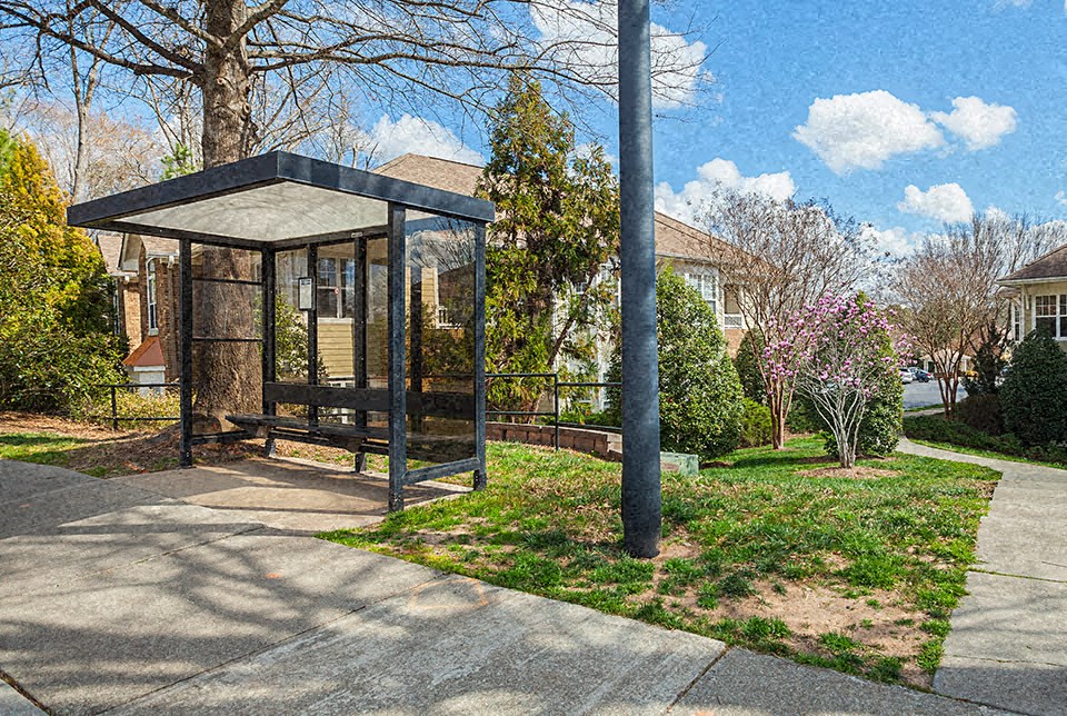 a gazebo on a sidewalk next to a tree