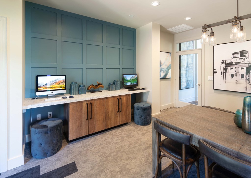 a dining room with a table and a desk with a computer