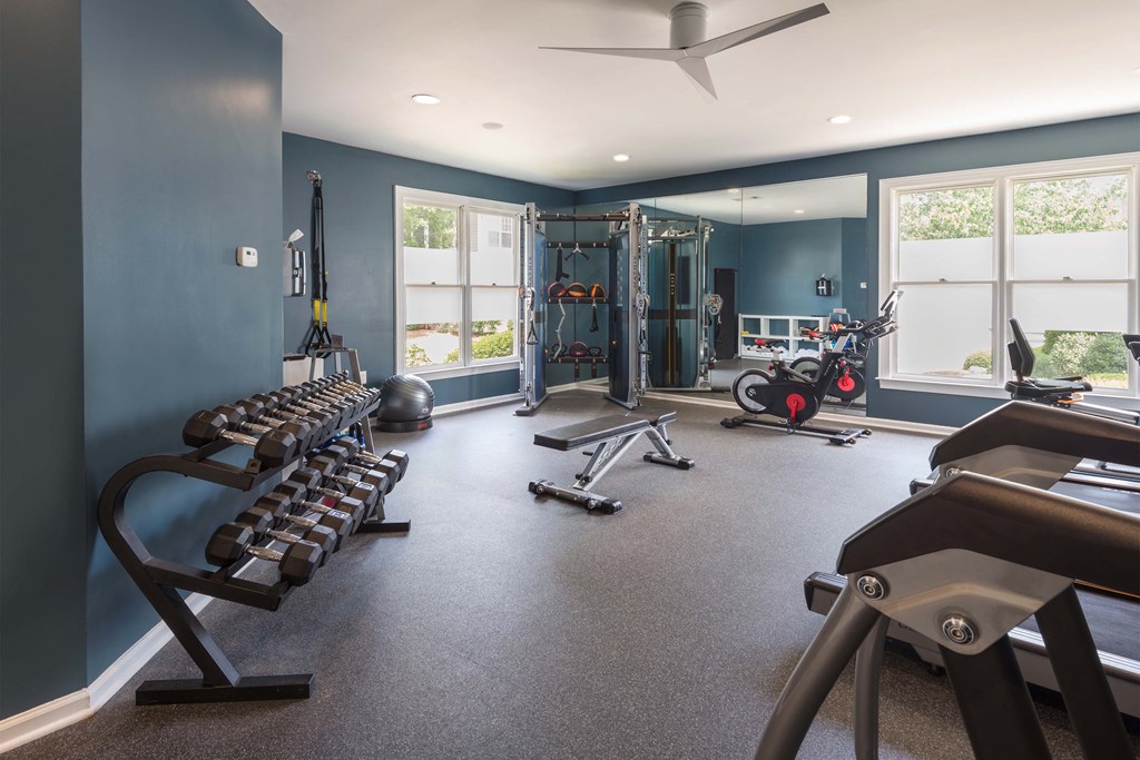 a home gym with exercise equipment and windows