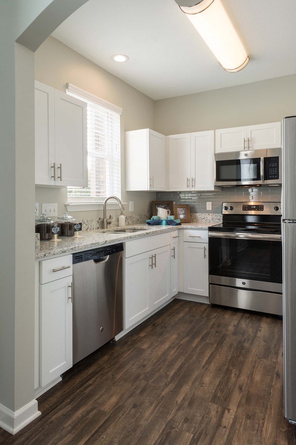 a kitchen with white cabinets and stainless steel appliances