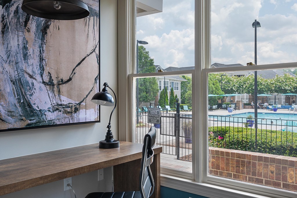 views of the pool from a home office with a desk and a large window