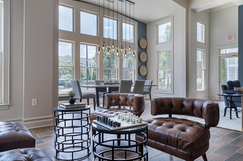 a living room with brown leather furniture and large windows