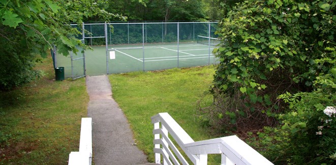 a path leading to a tennis court in a yard