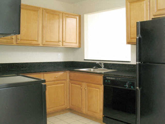 a kitchen with black appliances and wooden cabinets