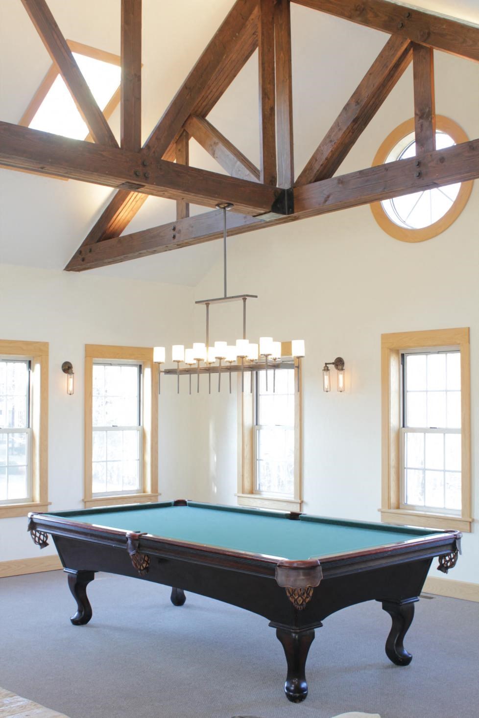 a pool table in a room with exposed beams