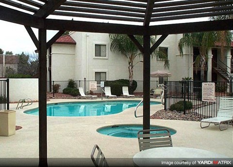 a swimming pool with chairs and a patio