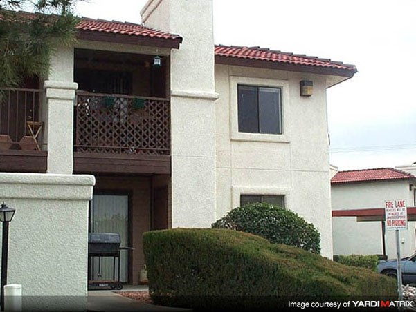 a white house with a balcony and a driveway