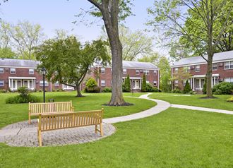 a park with a bench in front of a brick building