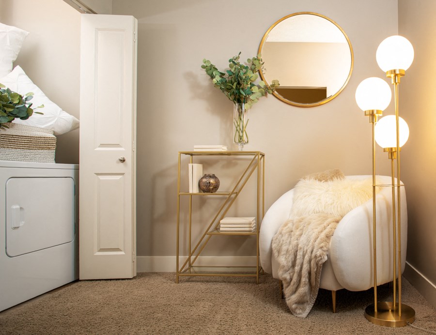 a small room with a bed and a mirror and lamps