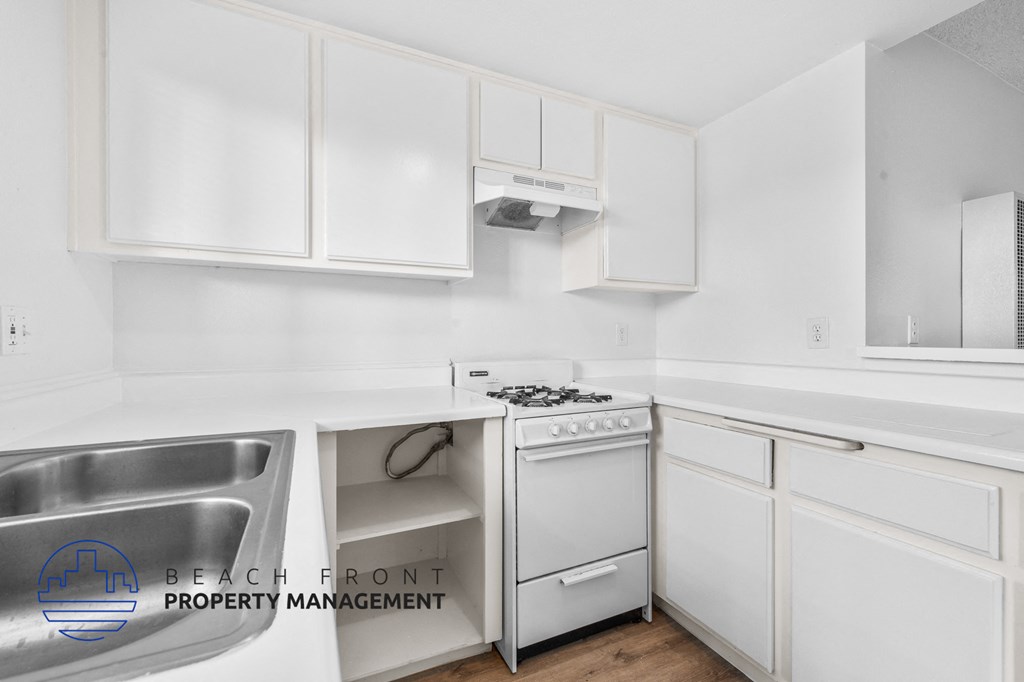 a kitchen with white cabinets and white appliances and a sink