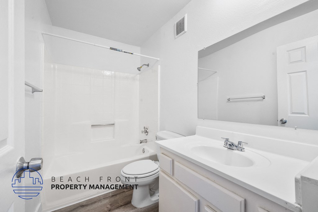 a white bathroom with a sink and toilet and a mirror