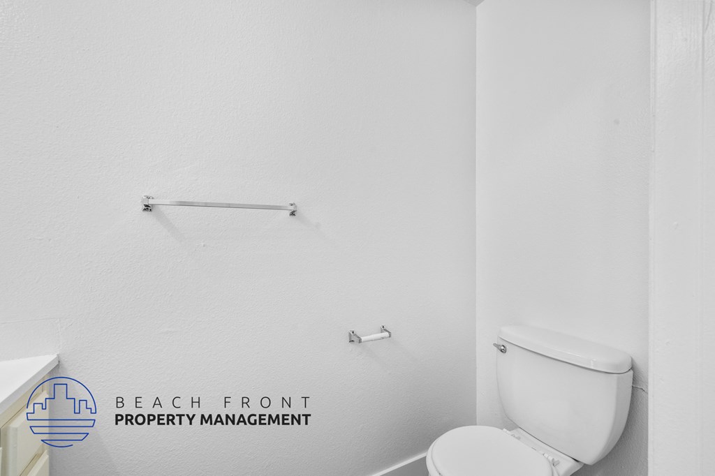 a bathroom with a toilet and a towel rack on the wall