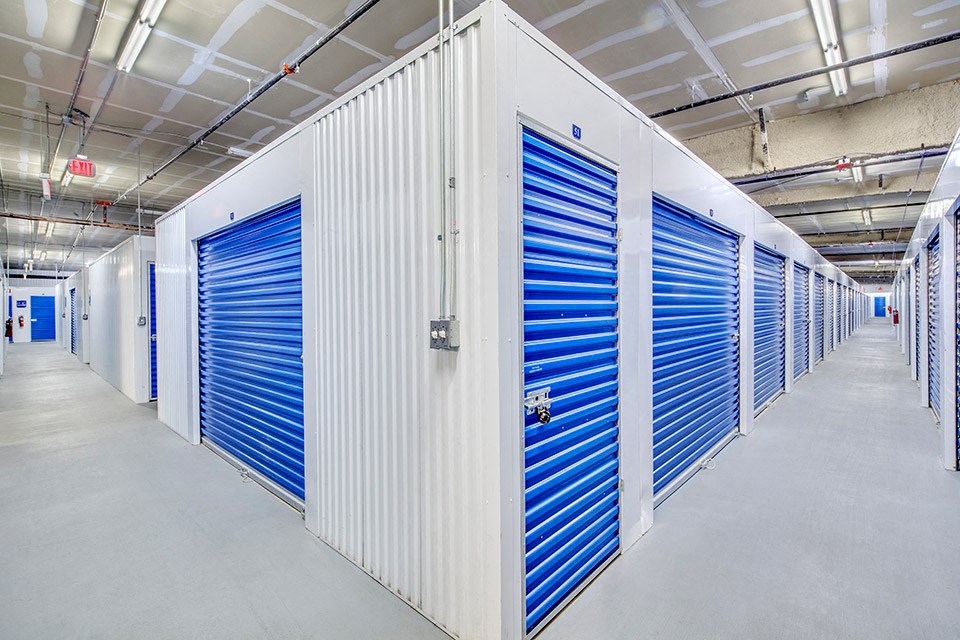 a row of blue and white storage doors in a building
