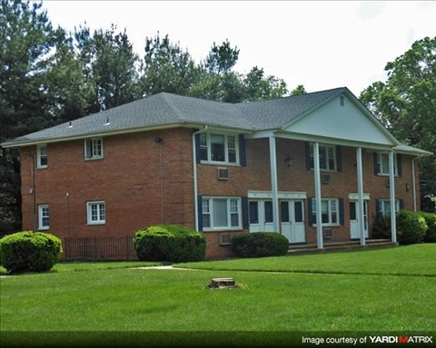 A brick house with a white door and windows.