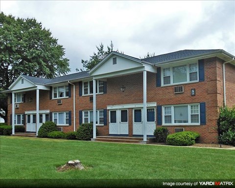 A brick house with a white door and windows.
