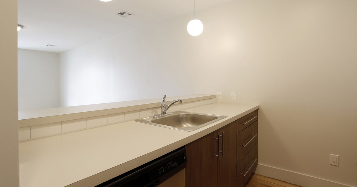 Kitchen sink and cabinets with view of living room