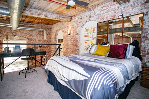 a bedroom with a bed and exposed brick walls