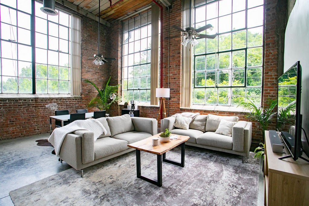 a living room with couches and a table in front of a window
