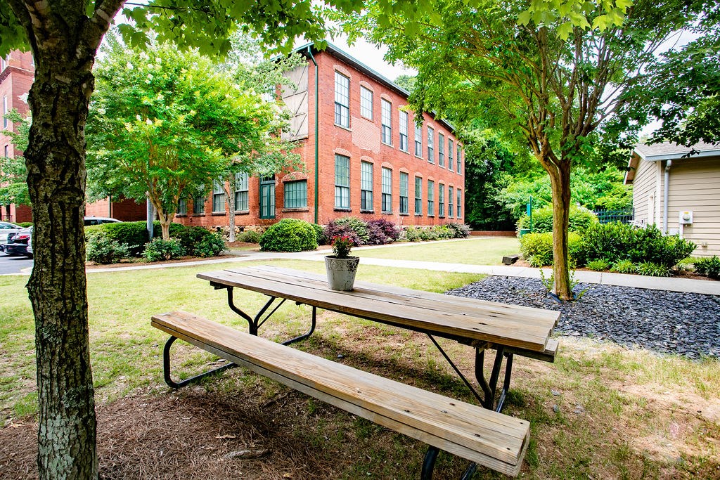 a picnic table in front of a brick building
