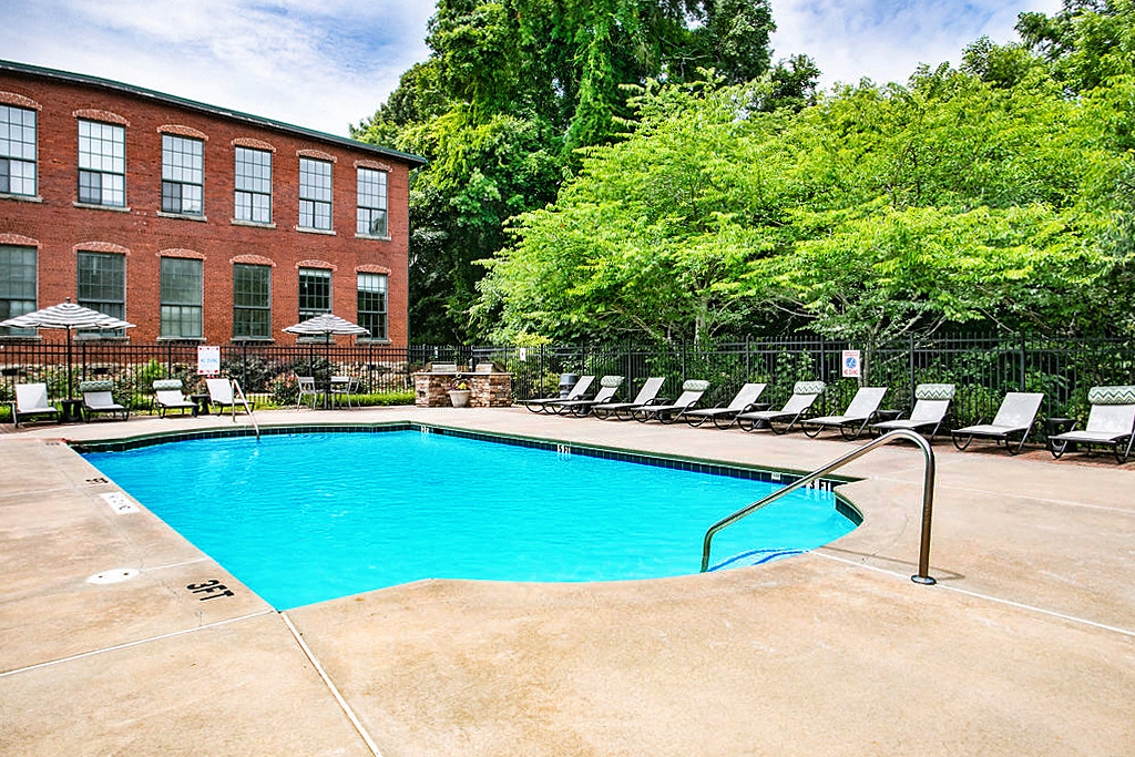 a large swimming pool in front of a brick building
