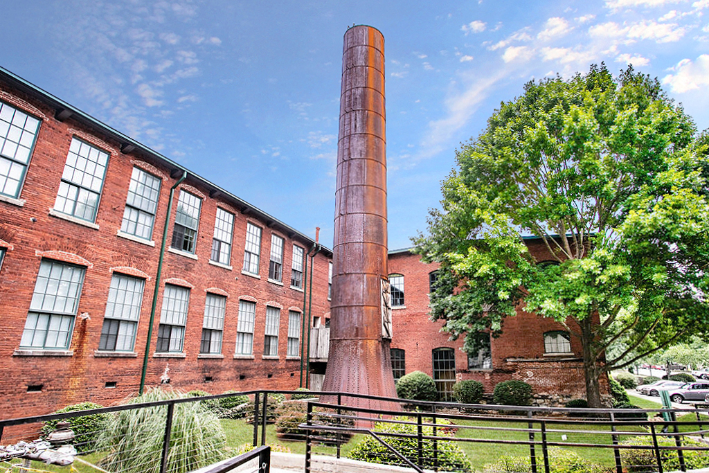 a large brick building with a tall chimney