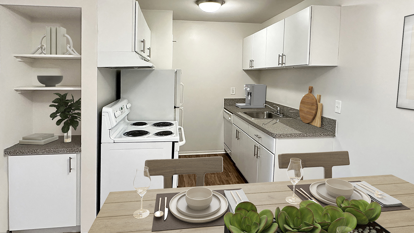 A white kitchen with a table set for two.