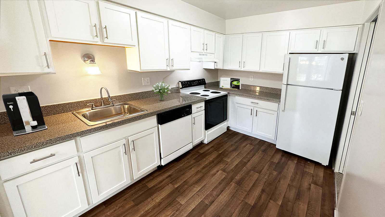 A kitchen with white cabinets and a black fridge.
