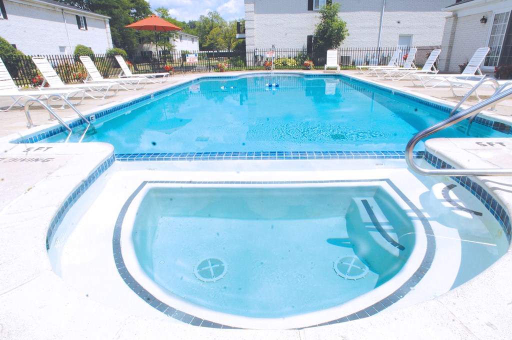 A small pool with a hot tub in the middle.