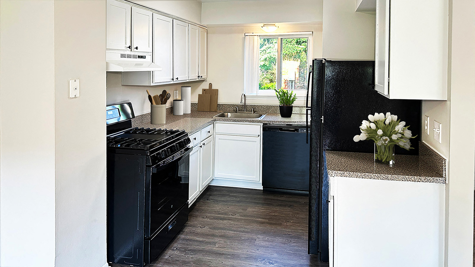 A kitchen with black appliances and white cabinets.