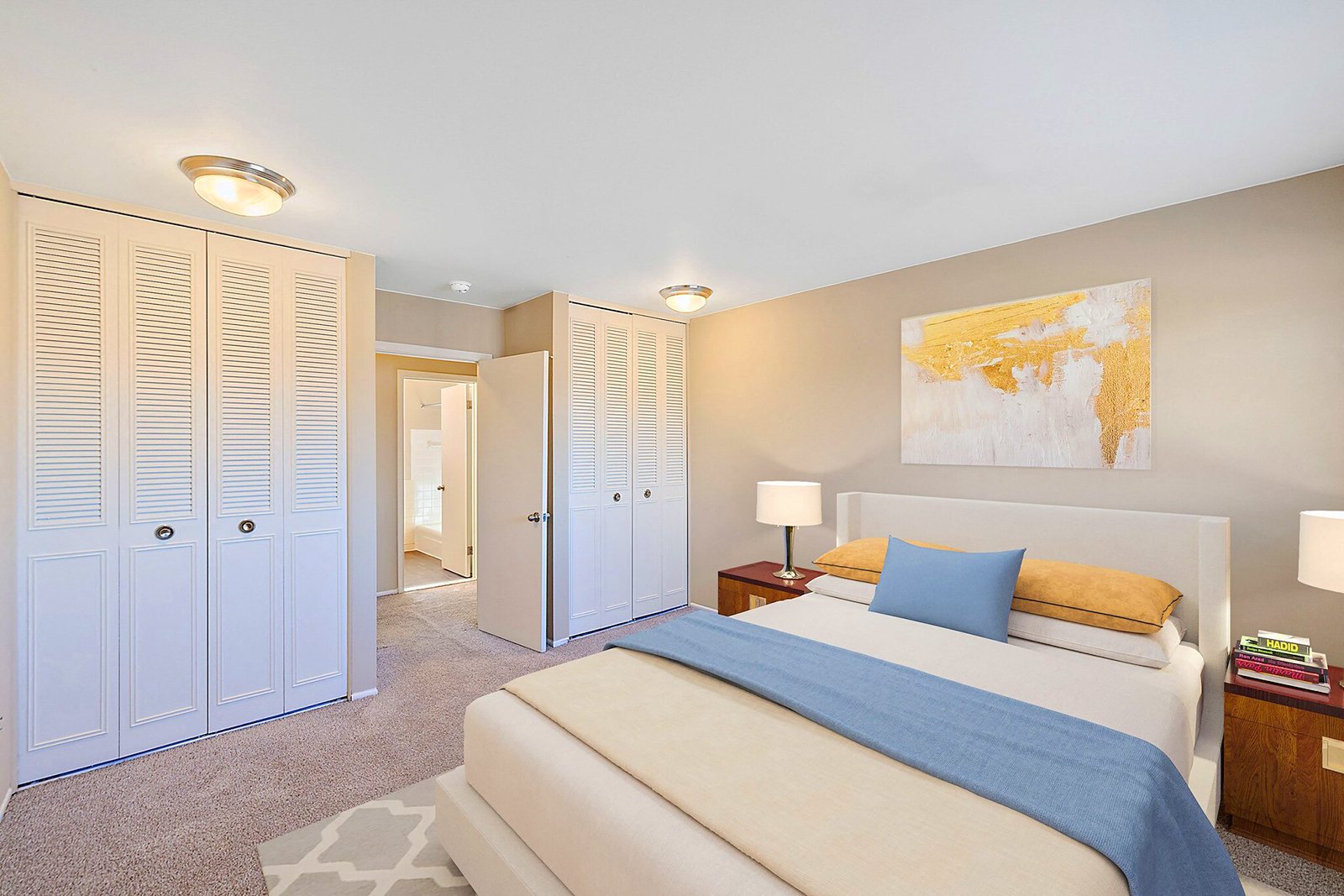 A bedroom with a large bed and a painting on the wall.