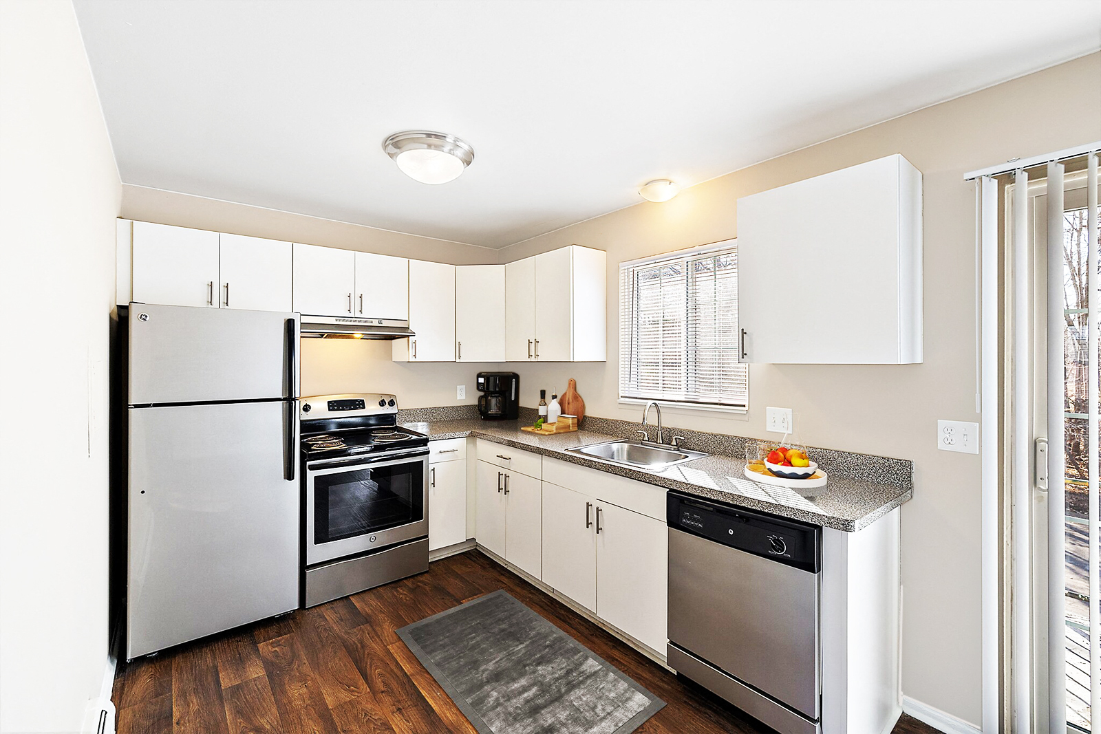 A modern kitchen with white cabinets and stainless steel appliances.