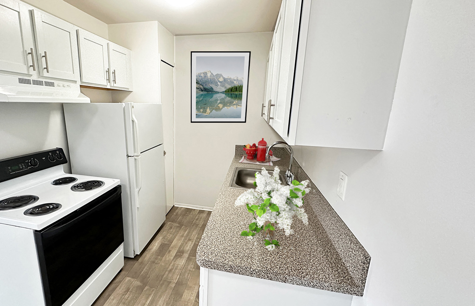 A kitchen with a white stove and white cabinets.