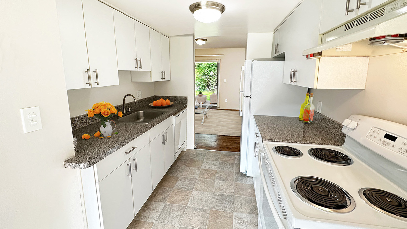 A kitchen with white cabinets and a white stove top oven.