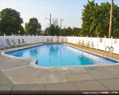 a swimming pool with white chairs around it