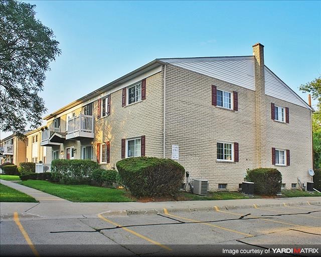 a brick building with a balcony and a street