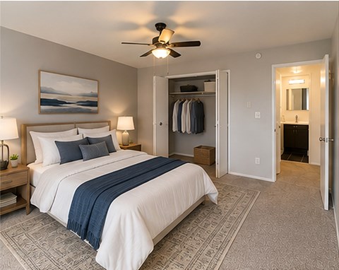 A bedroom with a large bed and a ceiling fan.