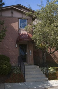 the front of a brick house with stairs in front of it