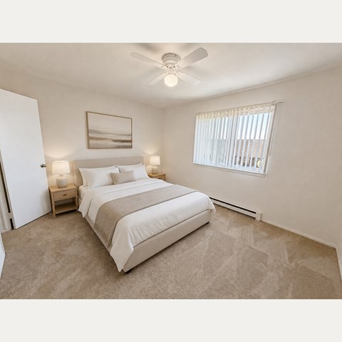 A bedroom with a large bed and a ceiling fan.