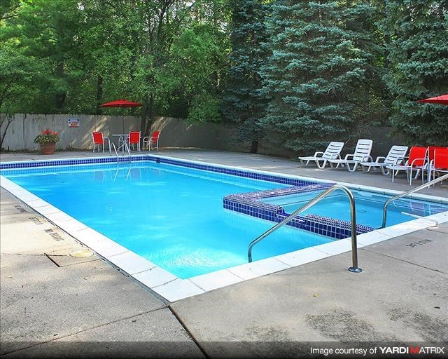 a swimming pool with chairs and chairs around it