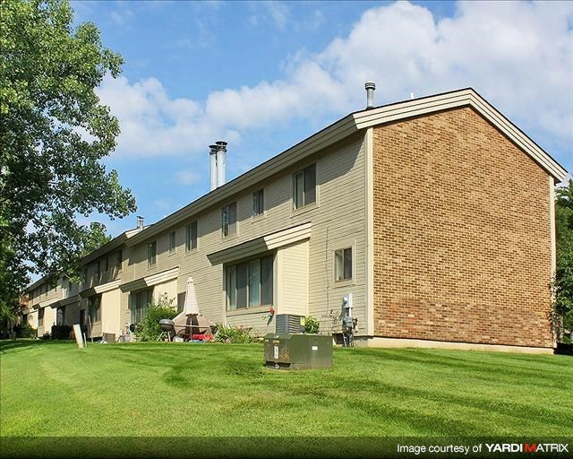a large brick house with a green lawn
