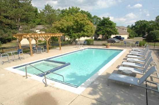a swimming pool with chairs around it