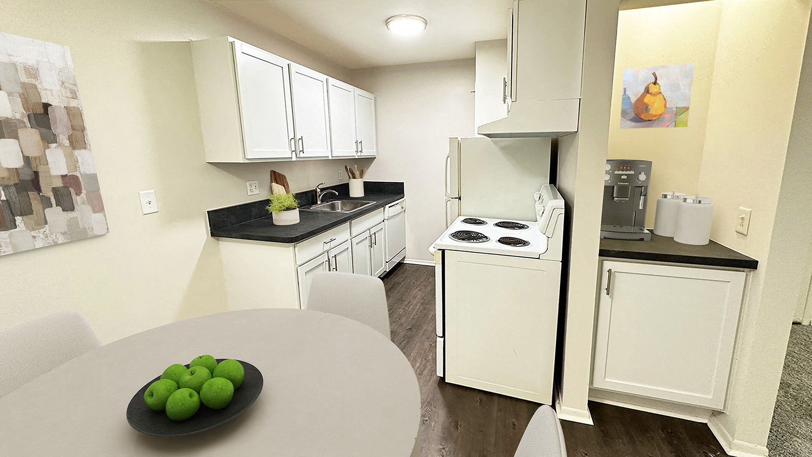 A kitchen with a table and a plate of green apples on it.