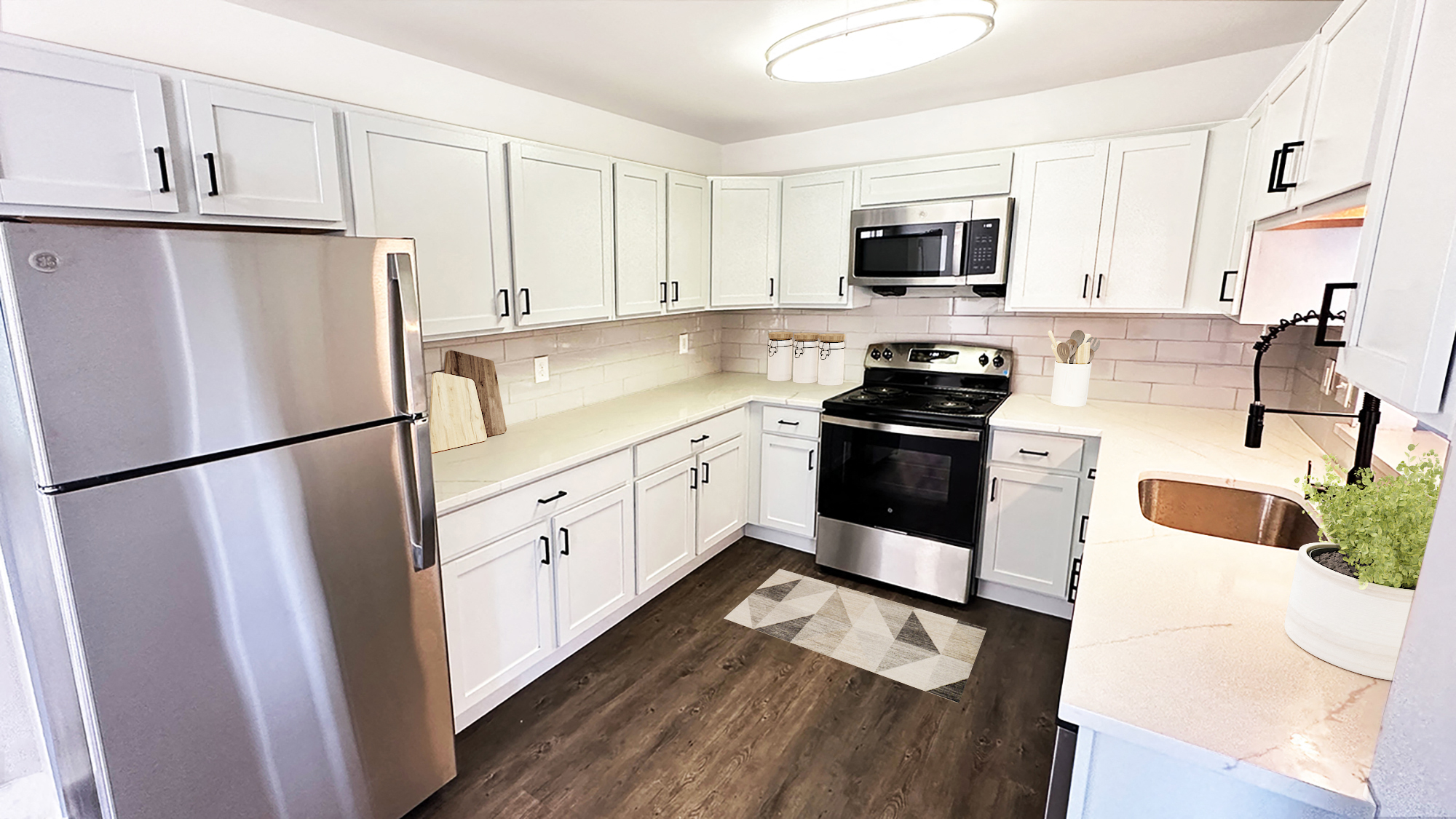A kitchen with white cabinets and a stainless steel refrigerator.
