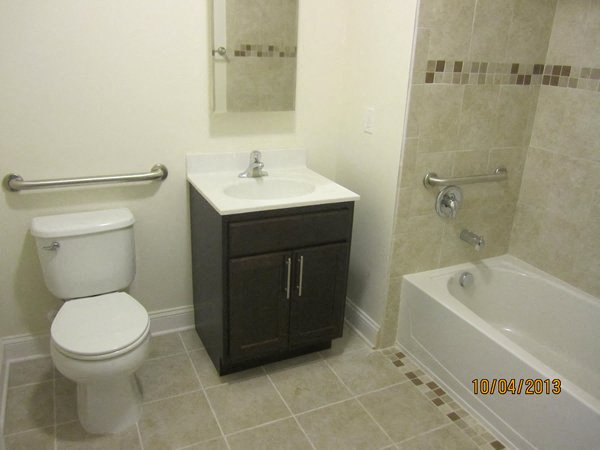 bathroom with wooden cabinet and beige patterned tiling