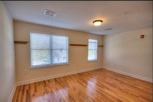 an empty living room with a hard wood floor