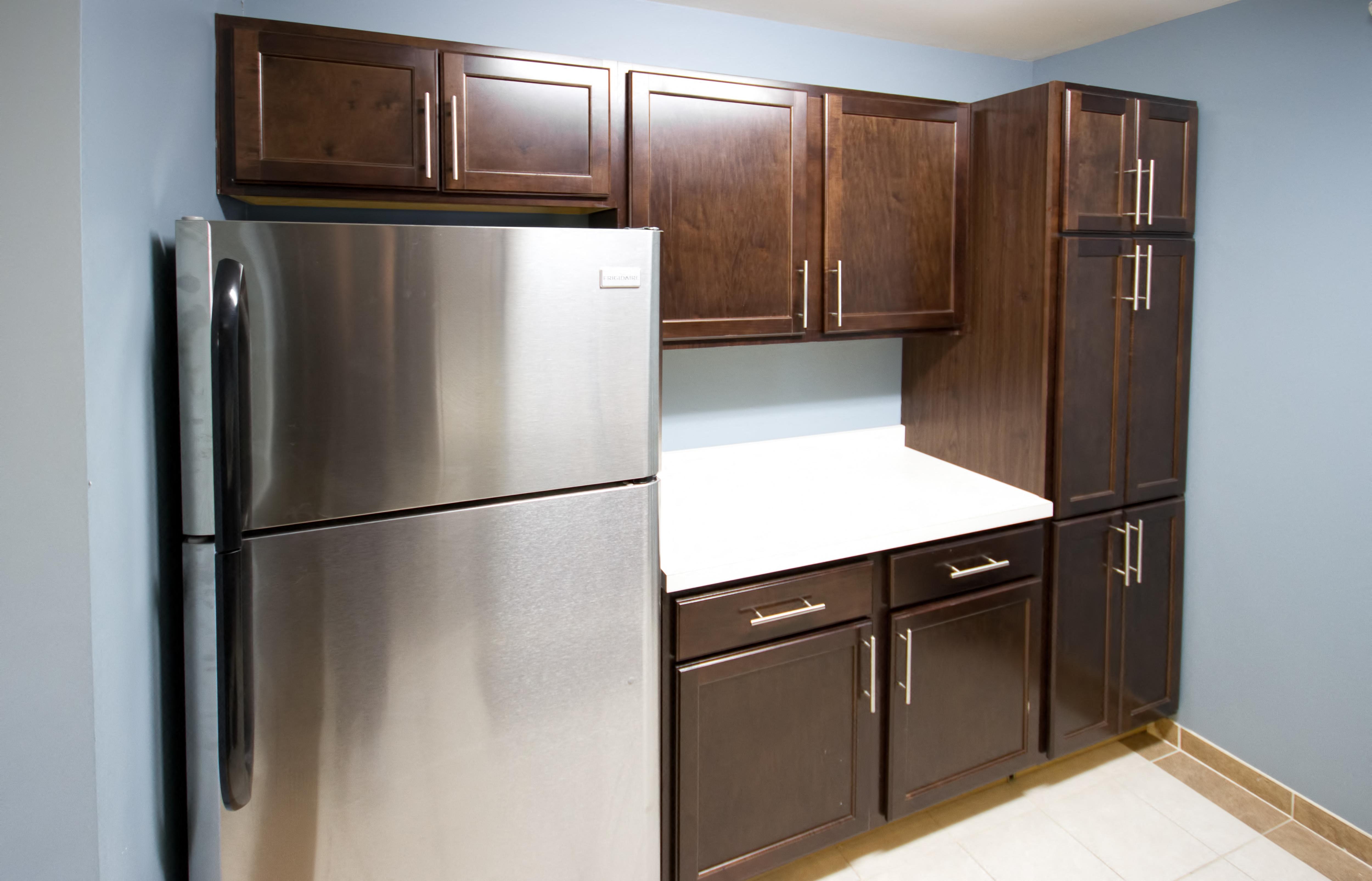 a kitchen with a stainless steel refrigerator and wooden cabinets